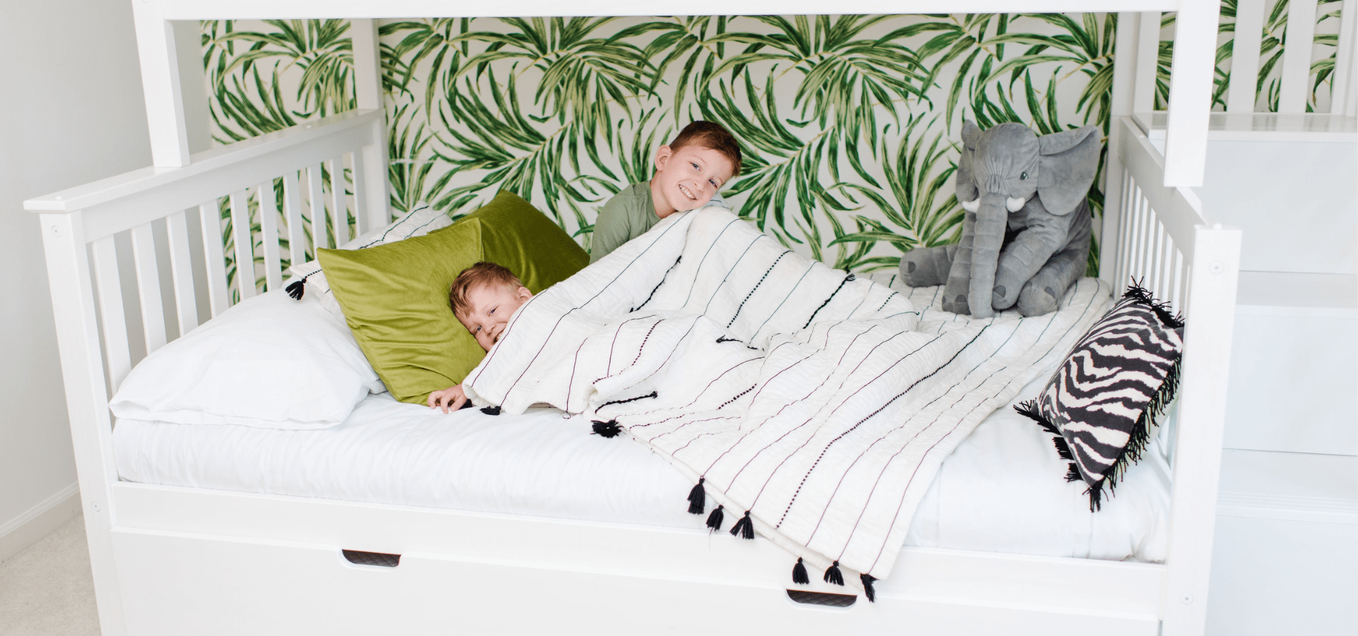 2 brothers snuggling on twin over full bunk bed with stairs Safari themed room