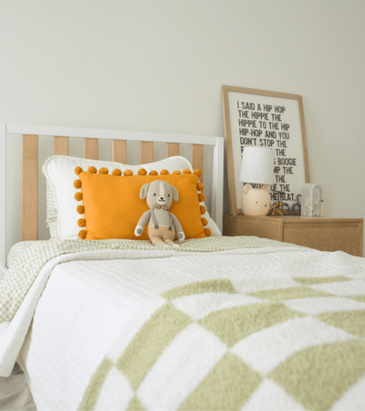 Natural wood twin over twin bunk bed with kid on ladder with playful bedroom decor