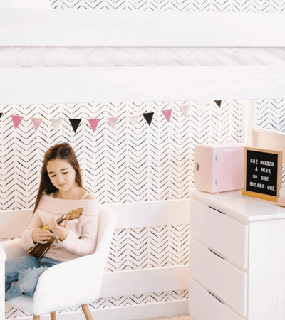 Solid wood high loft bed with shelf storage in shared boys room