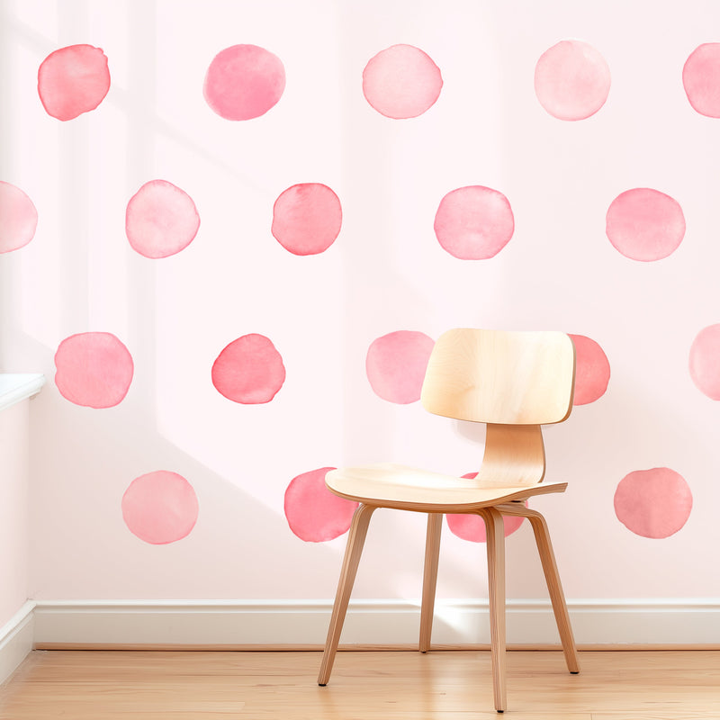 Modern wooden chair on hardwood floor against pastel pink watercolor polka dot wallpaper — nursery accent wall and kids' room decor
