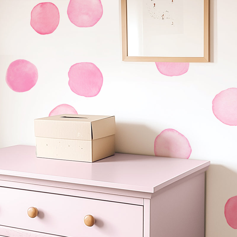 Nursery interior with pink polka dot wallpaper, pastel pink dresser with wooden knobs and cardboard storage box – kids room decor and organization
