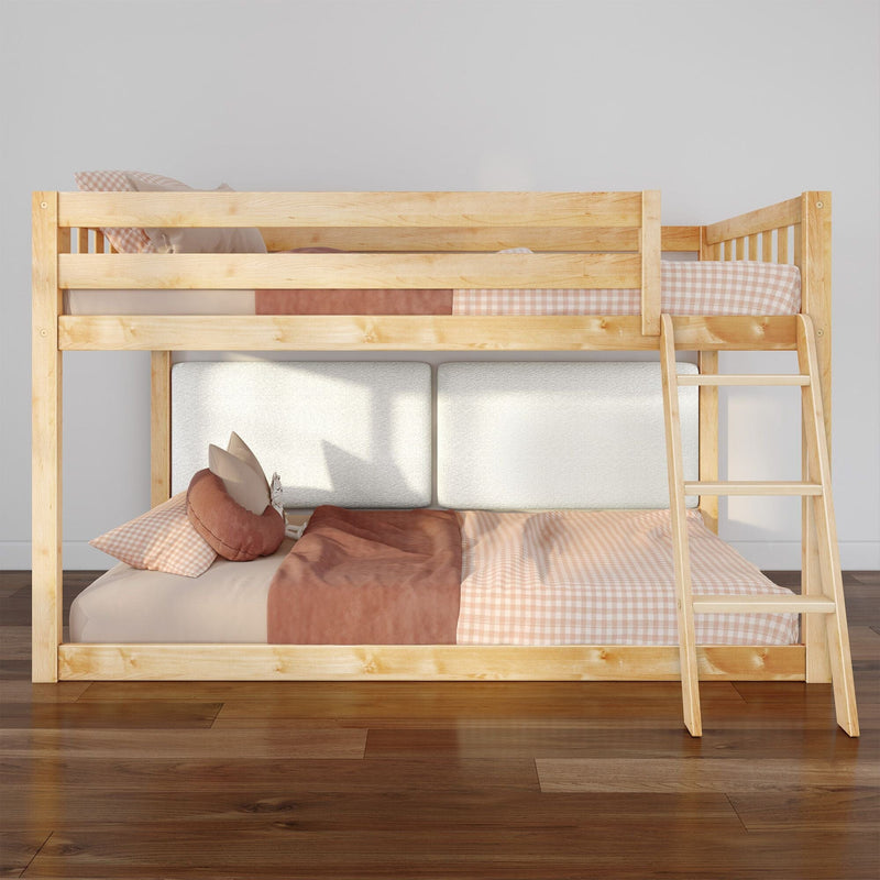 Light natural wood bunk bed with ladder, pink gingham bedding and throw pillows in a modern kids' bedroom on hardwood floors
