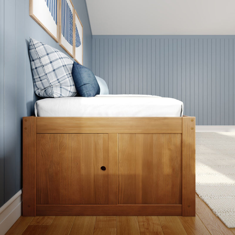 Wooden platform bed with white bedding and blue plaid and navy pillows against light-blue vertical shiplap wall in a modern coastal farmhouse bedroom