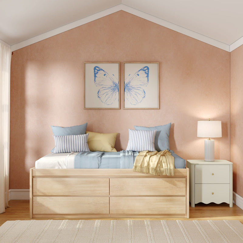 Cozy pastel bedroom interior with wooden storage bed, striped and solid pillows, blue butterfly framed wall art on a textured beige accent wall and bedside lamp