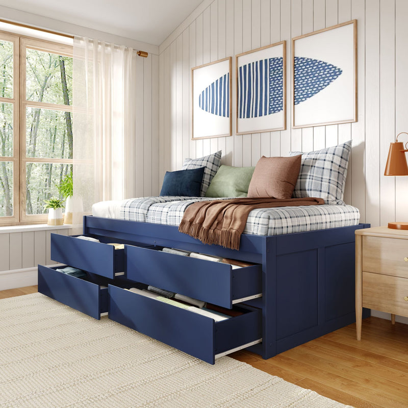 Navy blue storage platform bed with under-bed drawers, plaid bedding and accent pillows in a bright cozy modern bedroom with wooden window and blue abstract wall art