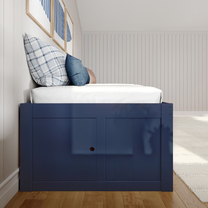 Navy blue wooden bed with white mattress and blue plaid and solid throw pillows against a white vertical shiplap wall with framed blue abstract art, modern coastal bedroom design