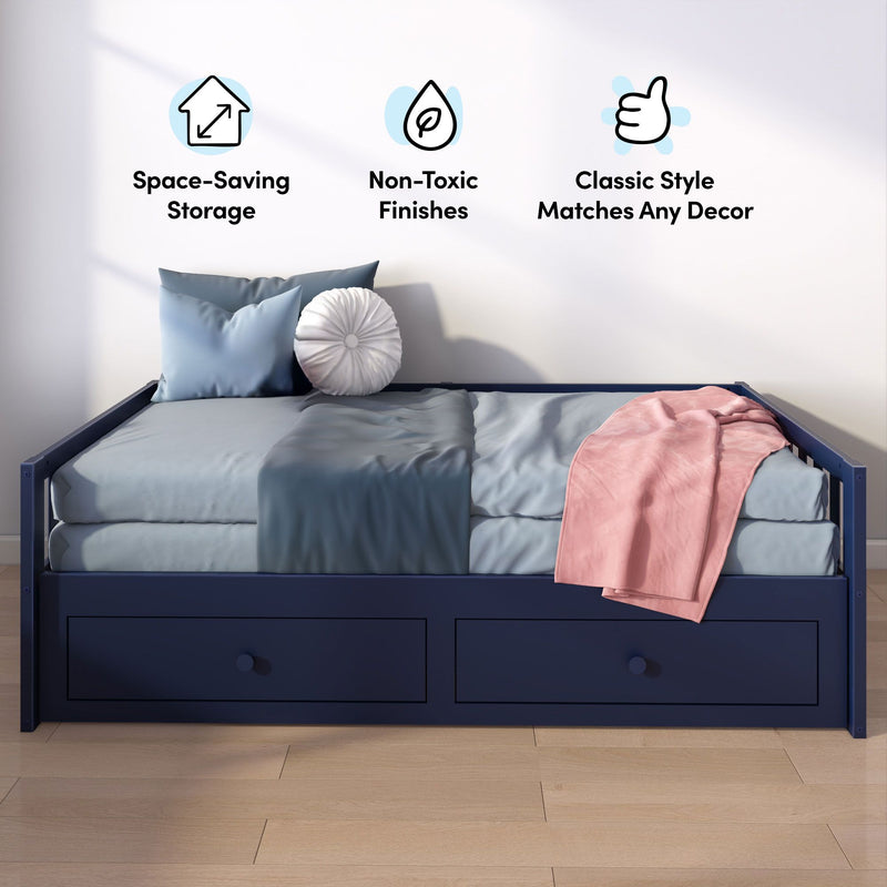 Modern navy blue storage daybed with under-bed drawers, light blue bedding, round white decorative pillow and pink throw in a small bedroom with wall icons highlighting space-saving storage, non-toxic finishes and classic style