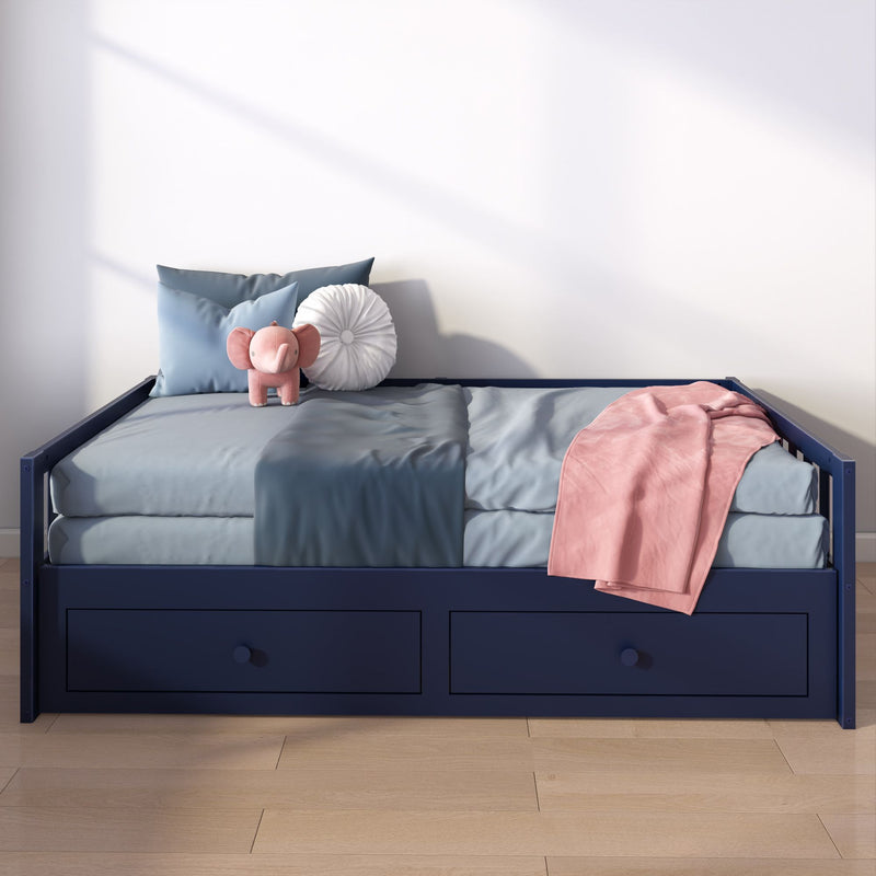 Children's navy storage daybed with blue bedding, pink throw and round white pillow, plush pink elephant toy on a light wood floor in a sunlit nursery
