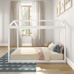 Children's bedroom with white Montessori-style floor bed, cozy striped bedding, and natural light streaming through a window with curtains.