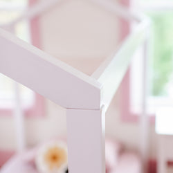 White canopy bed frame in a bright pink-themed bedroom.