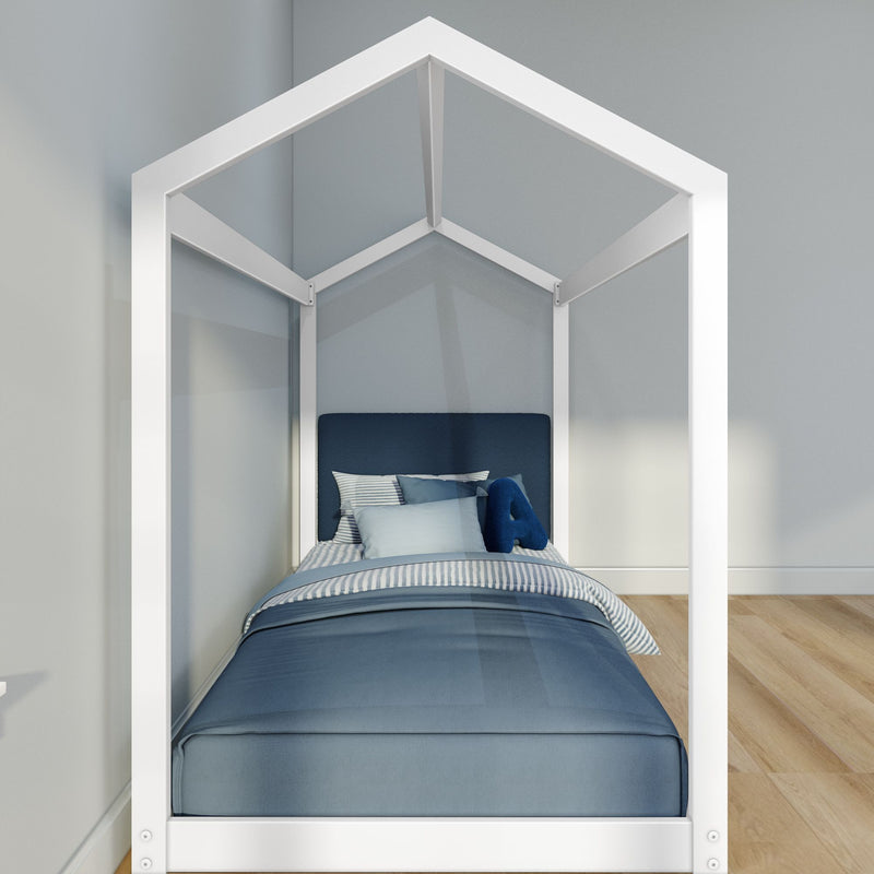 Children's white house-shaped bed frame with navy and light blue bedding, striped pillows and a blue headboard in a minimalist bedroom with light gray walls and hardwood floors
