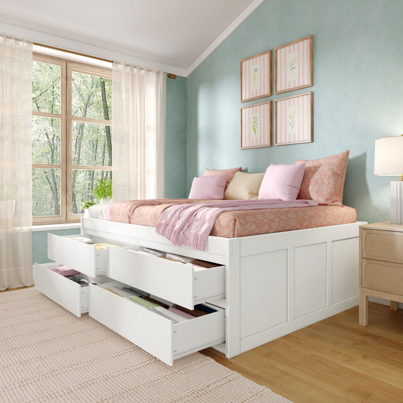 Storage bed with open under-bed drawers, pink floral bedding and pastel pillows in a mint-green bedroom with sheer curtains and botanical wall art
