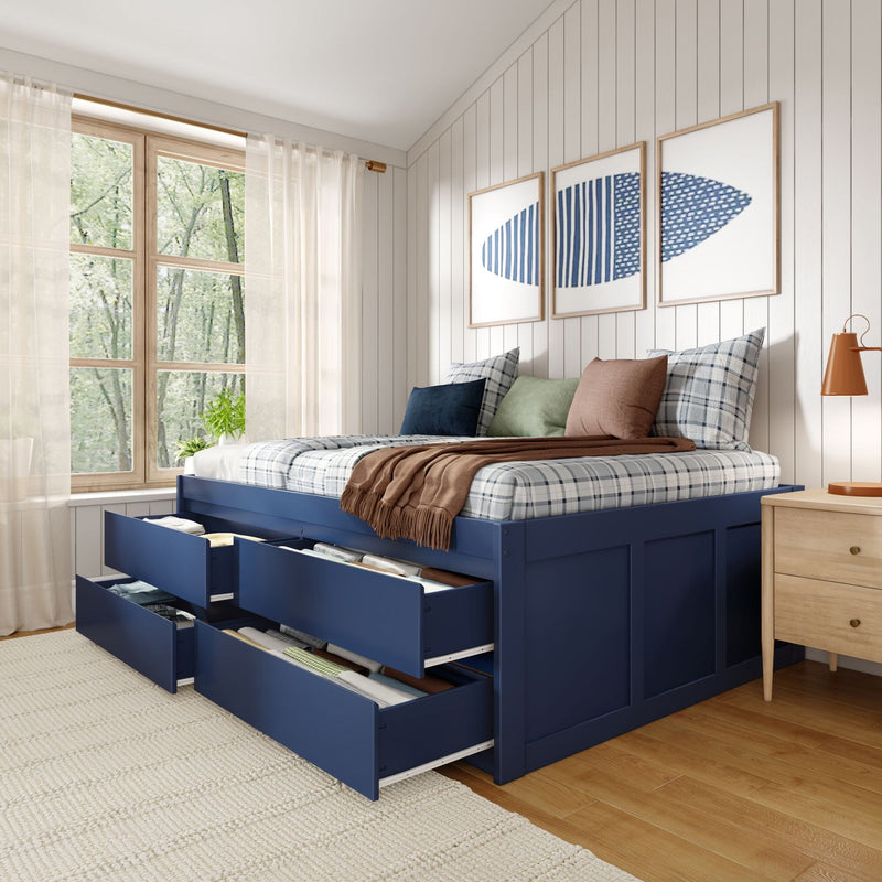 Cozy modern bedroom with navy blue storage bed (open drawers), plaid bedding and pillows, framed blue wall art and natural light from a wooden window