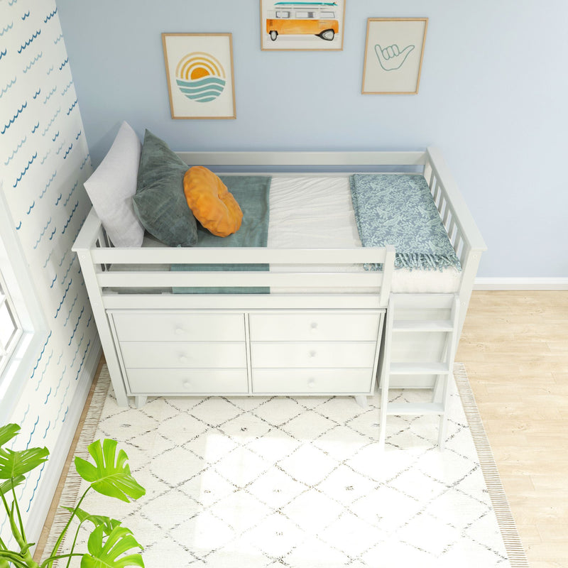 Top-down view of a white kids loft bed with built-in dresser and ladder in a coastal-themed nursery, teal and orange pillows, wave wallpaper and framed beach art