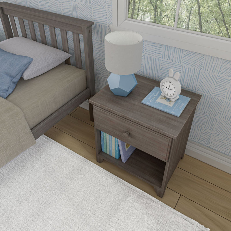 Wooden bedside table with books, blue modern lamp, and a small clock in a cozy bedroom setting.
