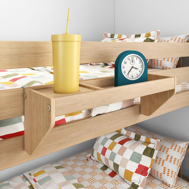 Wooden bunk bed with built-in bedside shelf holding a yellow straw cup and teal alarm clock, colorful geometric kids' bedding