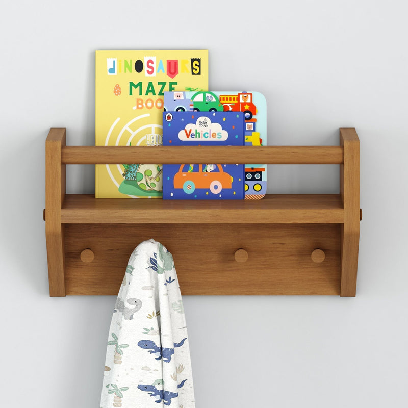 Children's wooden wall shelf with kids' books and a dinosaur-themed blanket.
