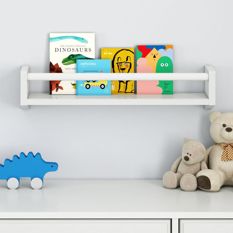 Children's bedroom bookshelf with colorful dinosaur books and plush teddy bears.