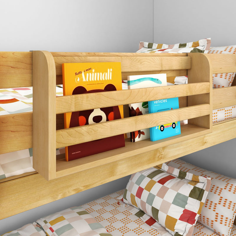 Light wood kids bunk bed with built-in bedside bookshelf holding colorful children's books and patterned pillows, space-saving kids bedroom storage solution