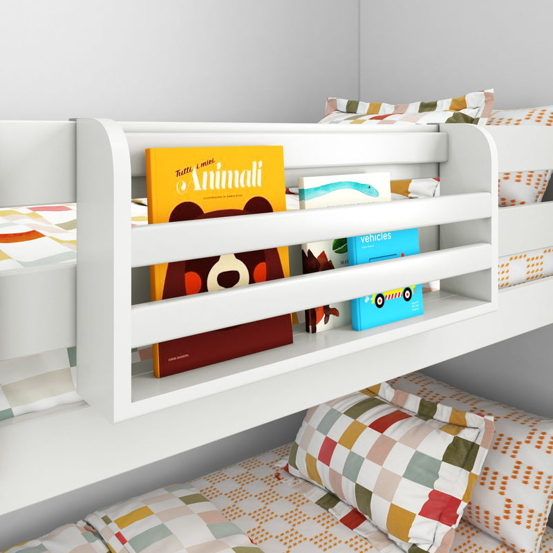 White children's bunk bed with built-in bookshelf holding colorful picture books, checkered pillows and patterned kids bedding