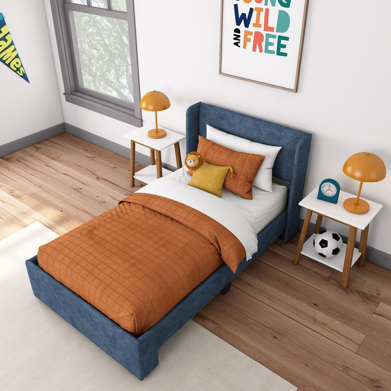 Cozy children's bedroom with blue upholstered bed, orange bedding, bedside tables, and decor.