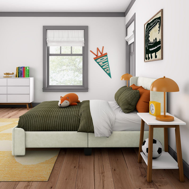 Kids bedroom interior with green striped bedding, fox plush toy, orange bedside lamps, personalized "Oliver" pennant, dinosaur wall art, white dresser with colorful books and toy airplane and soccer ball