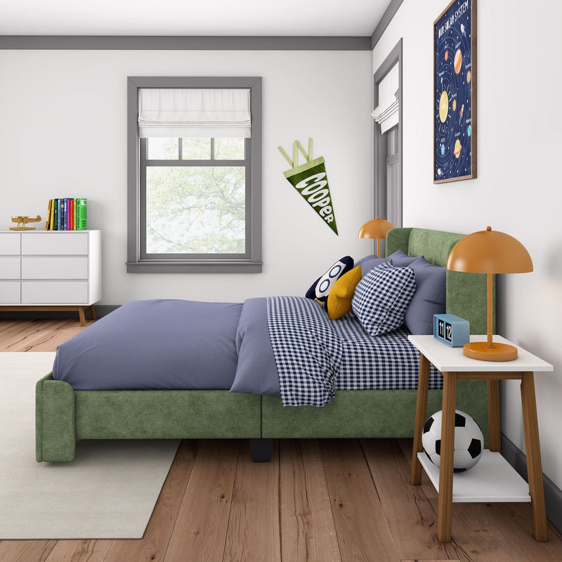 Children's bedroom with green upholstered bed, blue gingham bedding, orange bedside lamp, wall pennant, solar system poster, soccer ball and white dresser with books