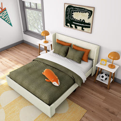 Cozy children's bedroom with green bedding, orange pillows, and playful animal decor.