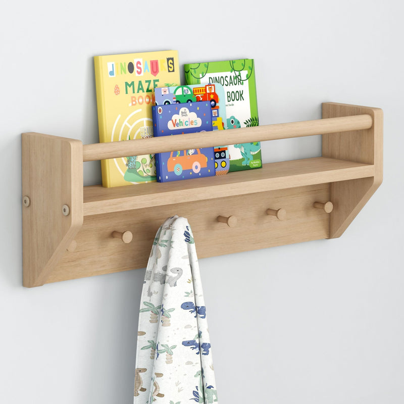 Wooden wall-mounted shelf with children's books and a hanging dinosaur-themed towel.
