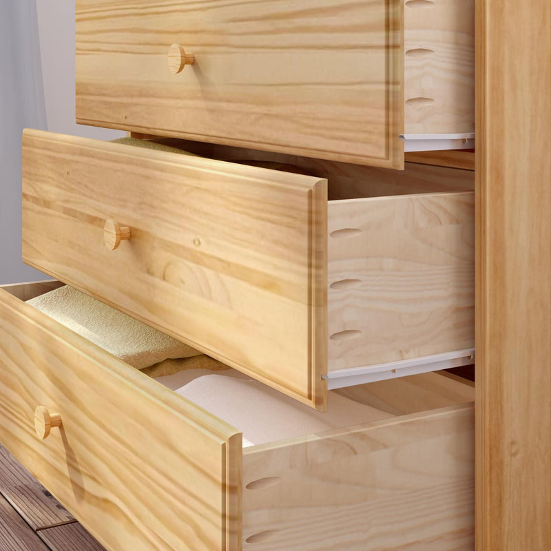 Natural pine dresser with three open drawers revealing folded linens, light wood bedroom storage chest with smooth finish