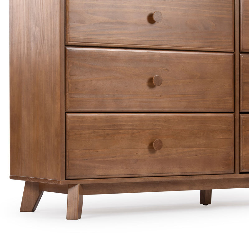 Close-up of mid-century modern wooden dresser with three drawers, round wooden knobs, tapered legs and warm walnut finish