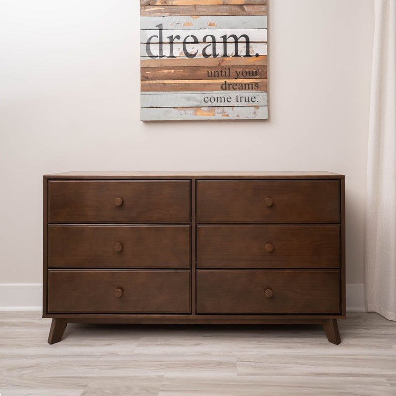 Mid-century modern six-drawer brown walnut dresser in minimalist bedroom with hardwood floor and "dream" inspirational wall art