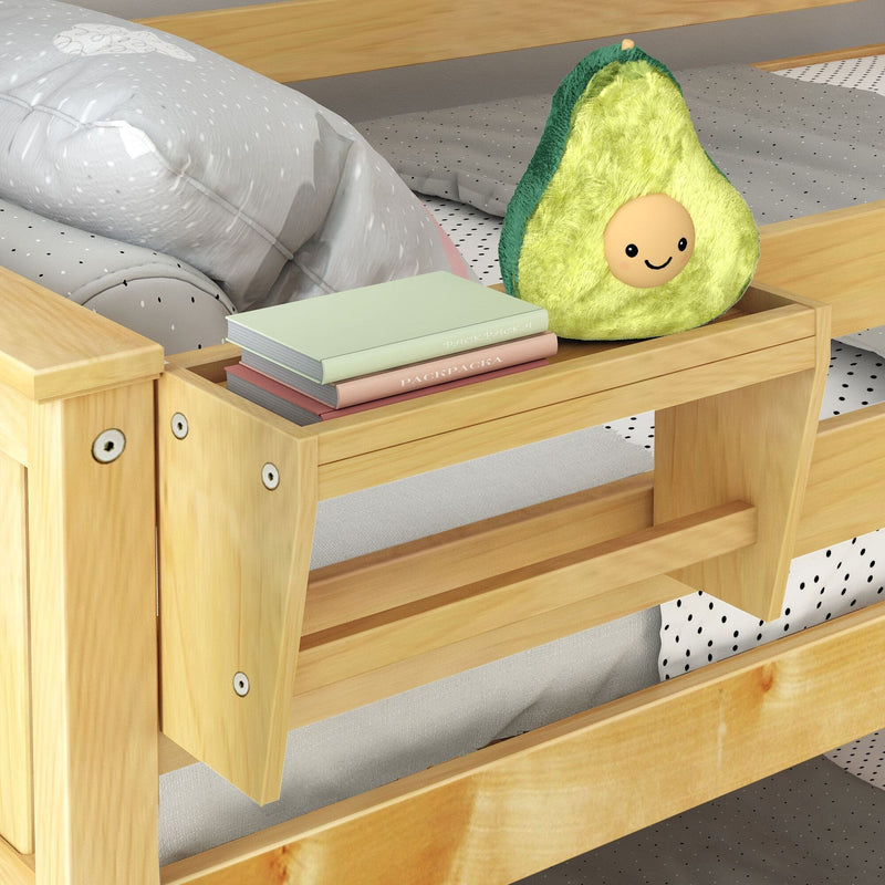 Children's wooden bunk bed with built-in side shelf holding a smiling plush avocado pillow and stacked pastel books on polka-dot bedding