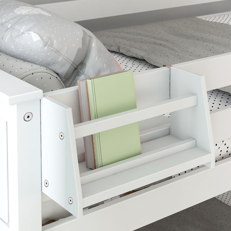 White wooden kids' bed with built-in bookshelf, gray polka-dot bedding and pale green hardcover book