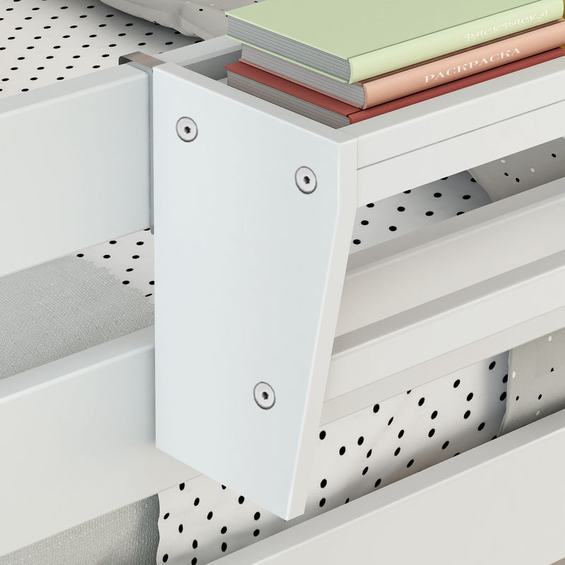 Close-up of stacked pastel hardcover books on the edge of a modern white wooden drawer with visible screws and a polka-dot fabric liner, nursery changing table storage detail