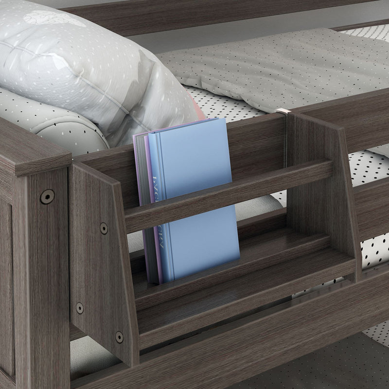 Dark wood bed frame with built-in bookshelf holding blue books, gray polka dot sheets and a white pillow