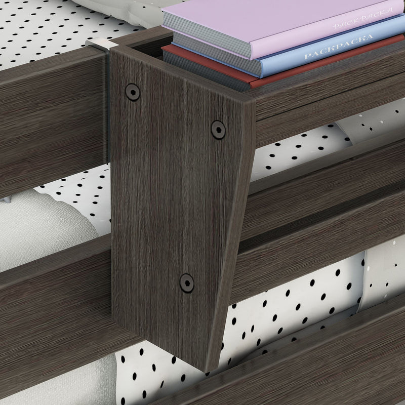 Dark wood bed frame corner with polka-dot mattress cover and stacked pastel hardcover books, modern bedroom decor