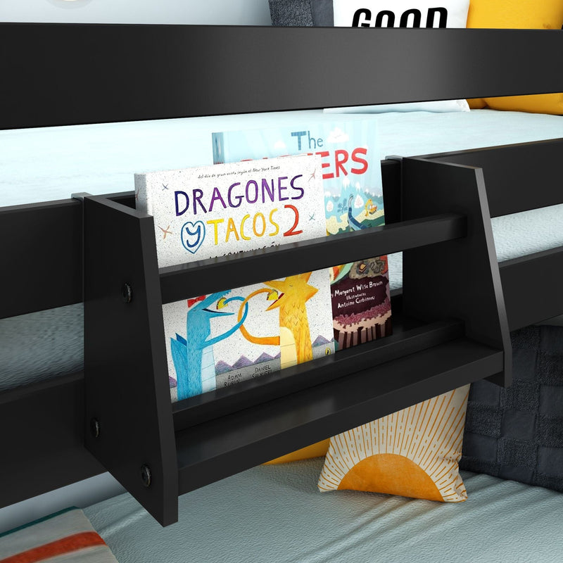 Black wall-mounted bedside bookshelf attached to bunk bed holding children's books including "Dragones y Tacos 2" and decorative pillows