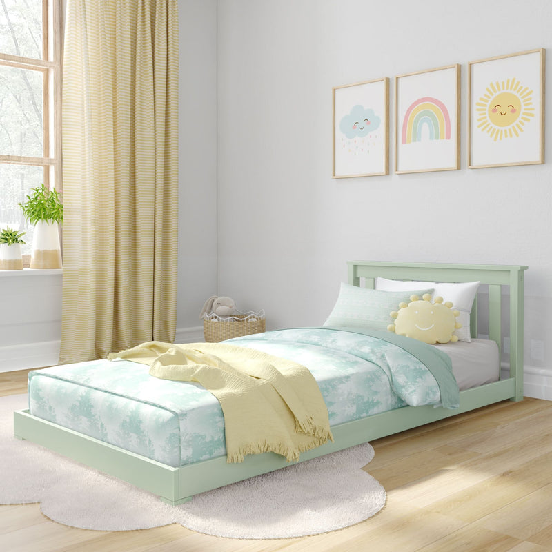 Pastel nursery bedroom with mint green toddler bed, aqua cloud-print bedding, yellow striped curtains, smiling sun-shaped pillow and rainbow wall art
