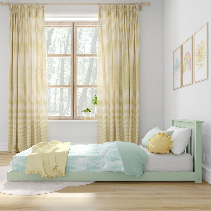 Pastel kids bedroom nursery with mint green bed, aqua-and-white bedding, yellow striped curtains, sun-shaped pillow, window plant and rainbow wall art