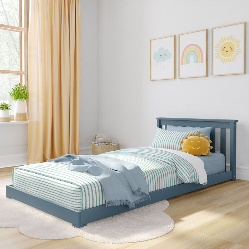 Bright modern children's bedroom with blue toddler bed, striped teal bedding, smiling sun plush, pastel rainbow and cloud nursery wall art, beige curtains and natural light