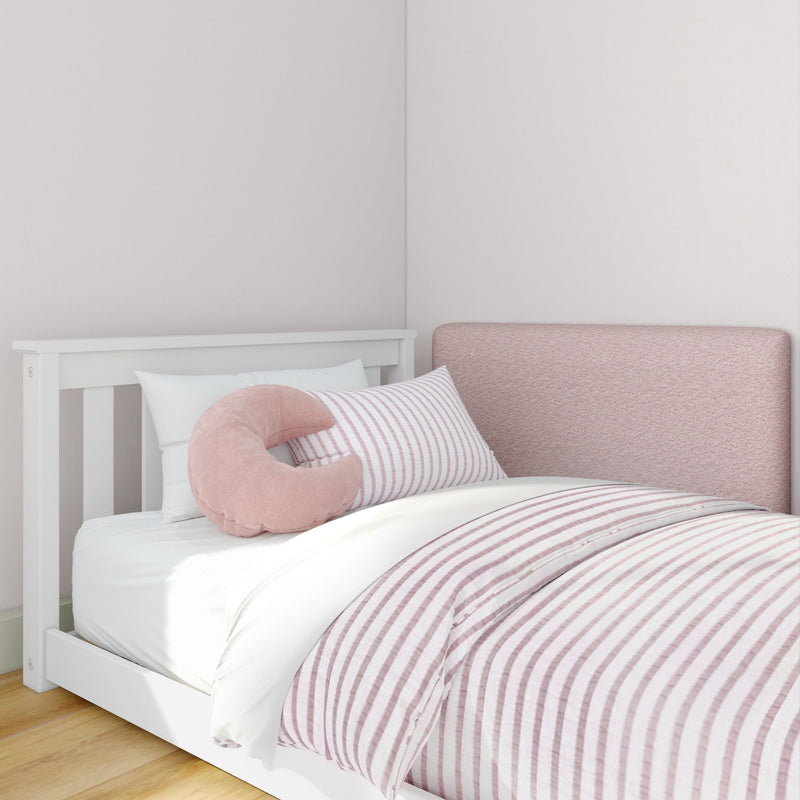 Pink striped nursery bedding in a white baby crib with a soft pink U-shaped pillow and upholstered headboard, modern baby nursery decor