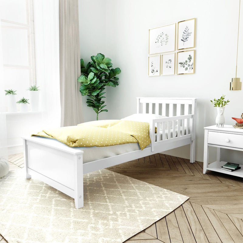 Modern minimalist nursery with white wooden crib, yellow polka-dot bedding, potted plants, gallery wall art and natural light
