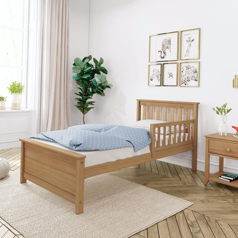 Scandinavian-style nursery with wooden toddler bed, blue polka-dot bedding, framed animal gallery wall, fiddle leaf fig plant and soft natural light