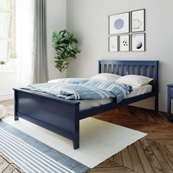 Blue wooden bed frame in a modern bedroom with white and blue bedding, houseplant, and framed sports art on the wall.