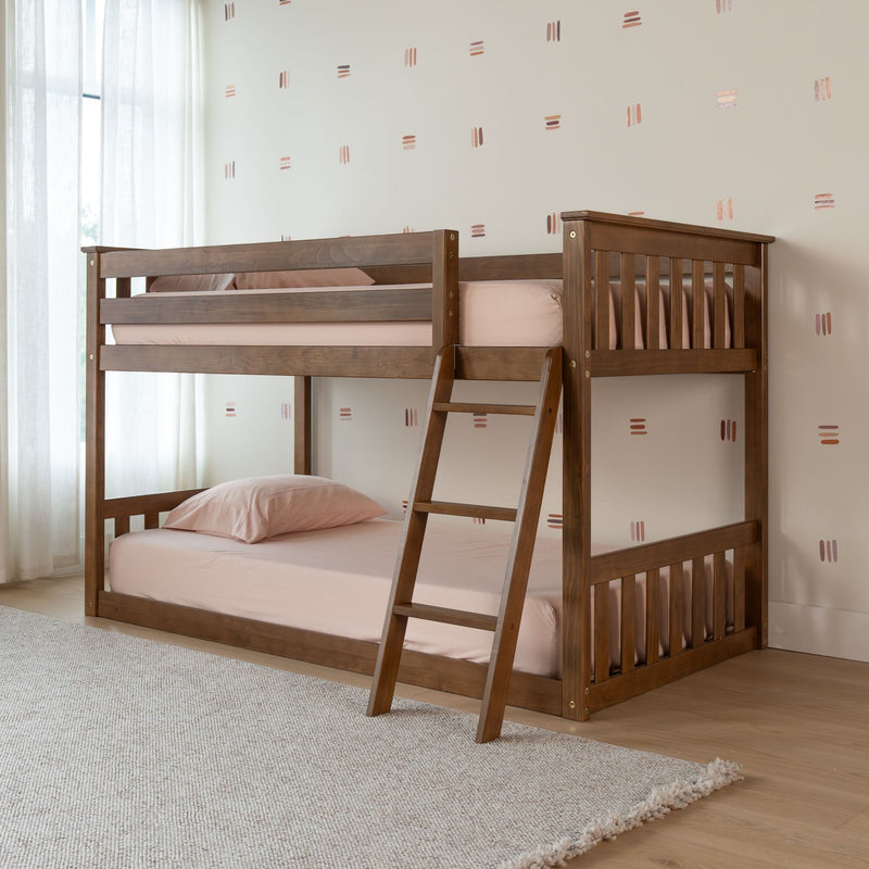 Solid wood bunk bed with ladder in a bright children's bedroom, blush pink bedding, neutral geometric wall decals, light wood floor and textured area rug — modern space-saving kids' room furniture