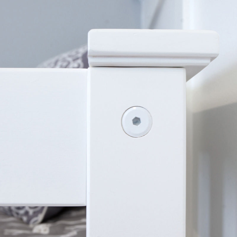 Close-up of white painted wooden bed frame corner with recessed hex screw and decorative molding, modern farmhouse bedroom furniture detail