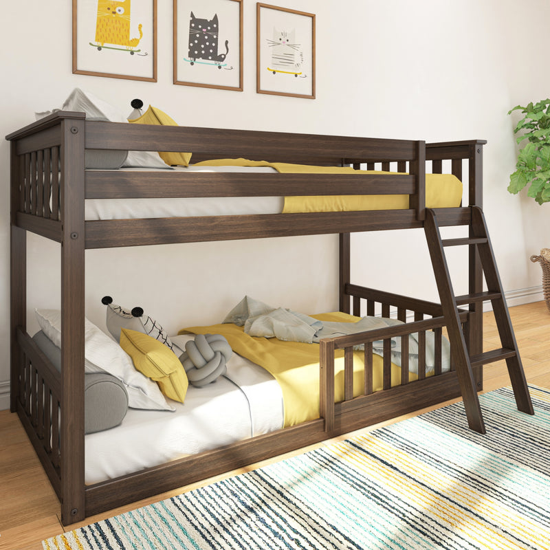 Dark wood twin-over-twin bunk bed in bright kids bedroom with yellow bedding, cat wall art, striped rug, ladder, and potted plant