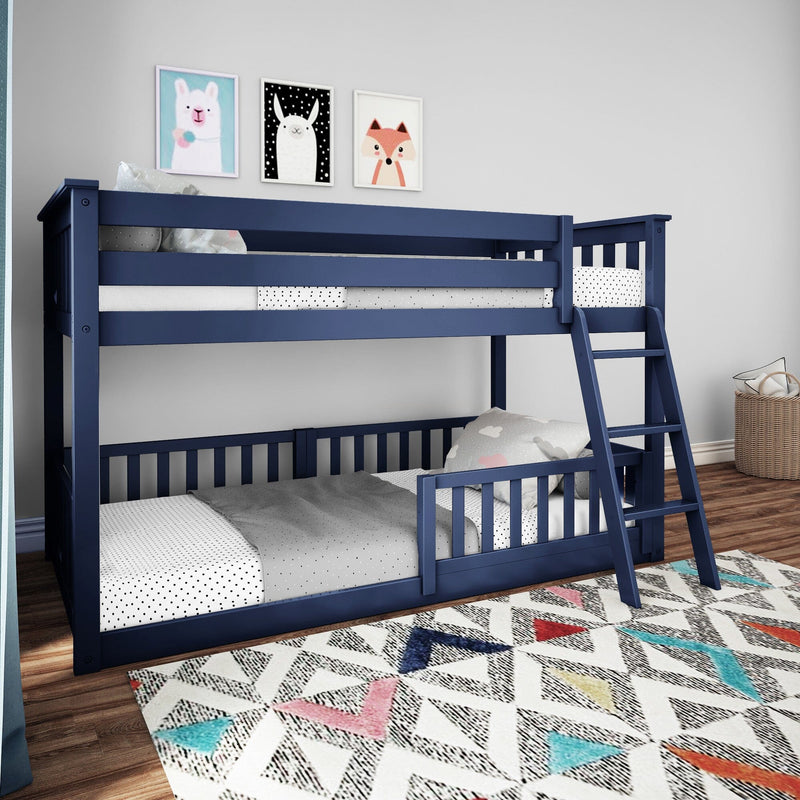 Navy blue wooden bunk bed with ladder in modern kids' bedroom, polka-dot bedding, framed animal wall art and colorful geometric rug