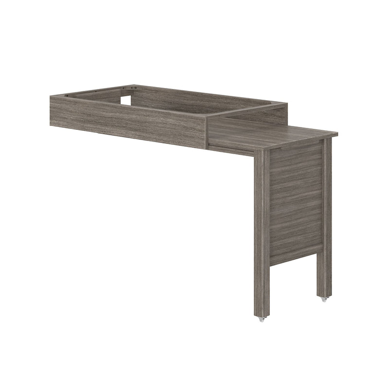 Gray wood bed frame extension with raised shelf guardrail, pull-out platform and caster wheels for compact bedroom storage